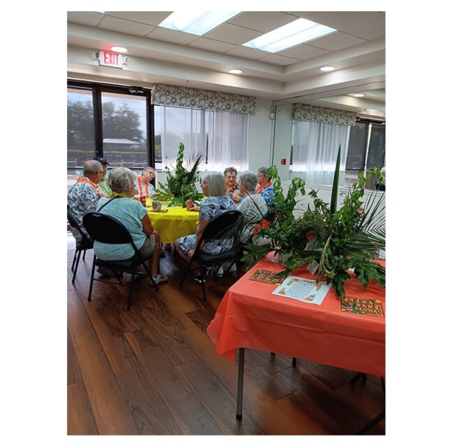 Guests at tropical-decorated tables during the August Island Time Cafe gathering