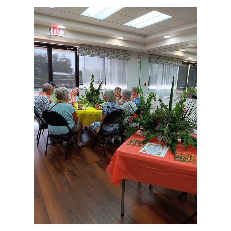 Guests at tropical-decorated tables during the August Island Time Cafe gathering