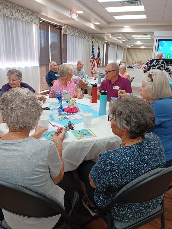 Guests gathered around the decorated birthday table at Coffee, Tea and Chat